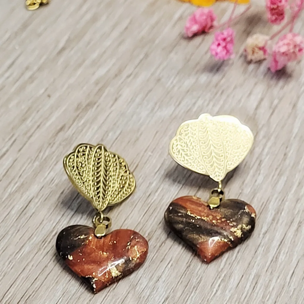 Boucles d'oreilles artisanales en forme de cœur marbré noir et terracotta avec éclats dorés.