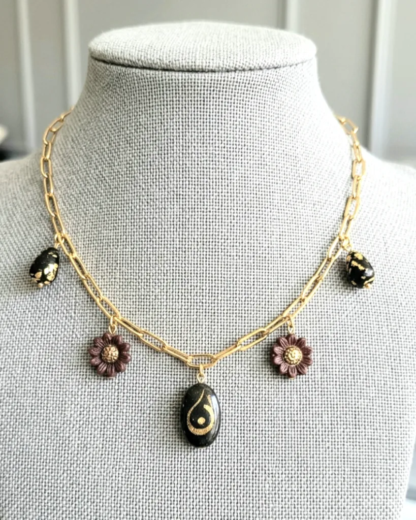 Collier artisanal composé d'un pendentif en résine noire avec calligraphie arabe 